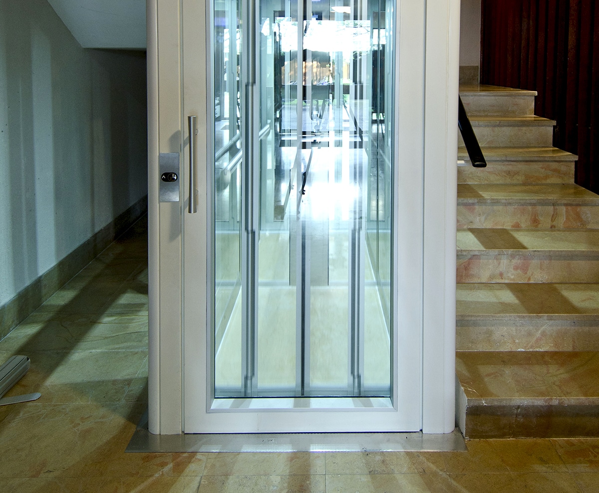 Ascenseur vitré en copropriété et habillage blanc